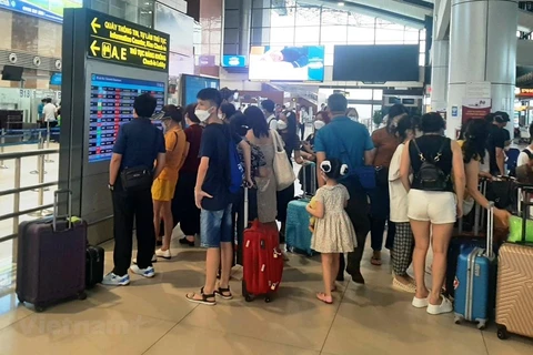 Hành khách theo dõi lịch bay của hãng hàng không tại sân bay Nội Bài. (Ảnh: Việt Hùng/Vietnam+) 