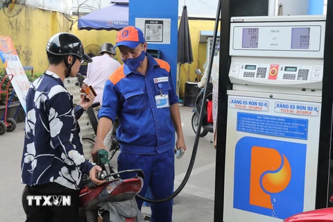 Người dân mua xăng tại một điểm kinh doanh xăng, dầu. (Ảnh: Trần Việt/TTXVN)