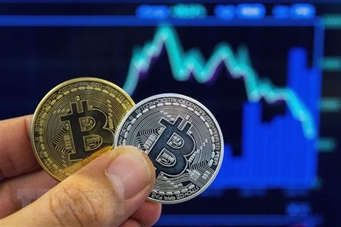 Hình ảnh mô phỏng đồng tiền điện tử Bitcoin tại cửa hàng giao dịch ở Tel Aviv, Israel. (Ảnh: AFP/TTXVN) 