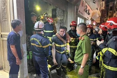Lực lượng Cảnh sát phòng cháy chữa cháy và cứu nạn cứu hộ đưa người bị nạn ra khỏi đám cháy. (Ảnh TTXVN phát)