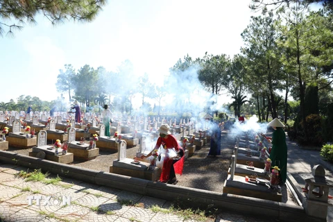 Người dân thắp hương tưởng nhớ, tri ân công ơn của các anh hùng, liệt sỹ tại Nghĩa trang quốc gia đường 9. (Ảnh: Hoàng Hiếu/TTXVN)