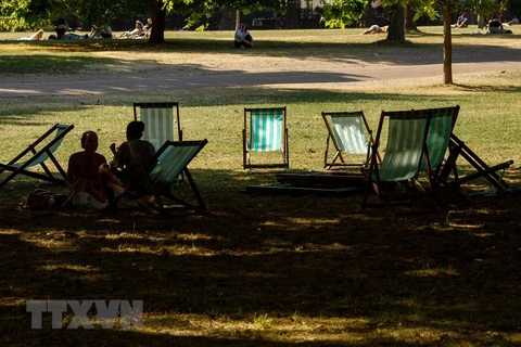Người dân tránh nắng nóng tại một công viên ở London, Anh khi nhiệt độ lên cao kỷ lục trên 40 độ C, ngày 19/7. (Nguồn: THX/TTXVN) 