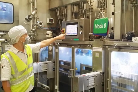 Điều khiển hệ thống máy chiết rót nước tự động tại nhà máy Công ty La Vie tại Long An (Liên doanh giữa Công ty Thương mại tổng hợp Long An và Tập đoàn Nestlé Waters). (Ảnh: Minh Hưng/TTXVN) 