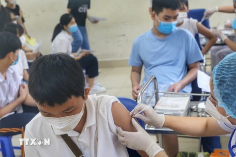Nhân viên y tế phường Minh Khai tiêm mũi vaccine nhắc lại cho học sinh trường THCS Hà Huy Tập. (Ảnh: Tuấn Đức/TTXVN)