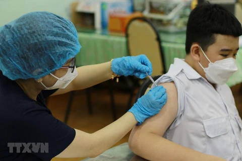 Nhân viên y tế tiêm vaccine phòng COVID-19 cho học sinh trường Trung học cơ sở Hồng Bàng (Quận 5). (Ảnh: Thu Hương/TTXVN) 