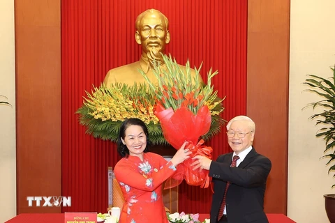 Chủ tịch Hội Chữ thập Đỏ Việt Nam Bùi Thị Hòa tặng hoa chúc mừng Tổng Bí thư Nguyễn Phú Trọng. (Ảnh: Trí Dũng/TTXVN) 