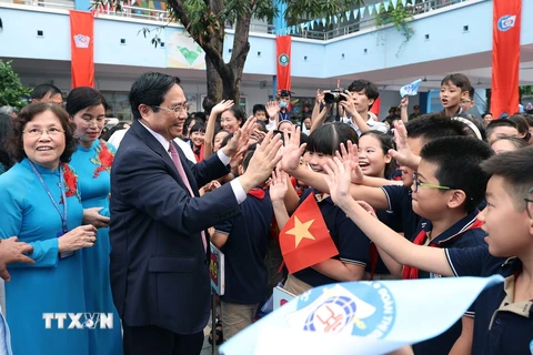 Thủ tướng Phạm Minh Chính với học sinh Trường Tiểu học Đoàn Thị Điểm. (Ảnh: Dương Giang/TTXVN)