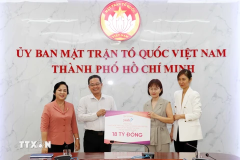 Ông Phạm Minh Tuấn, Phó Chủ tịch Ủy ban Mặt trận Tổ quốc Việt Nam Thành phố Hồ Chí Minh (thứ 2 từ trái sang) tiếp nhận tượng trưng số hàng hóa do đại diện Công ty Cổ phần Tập đoàn Yeah1 trao tặng. (Ảnh: Xuân Khu/TTXVN)