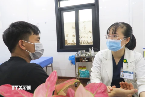 Bác sỹ Bệnh viện Y học cổ truyền Thành phố Hồ Chí Minh tư vấn điều trị cho bệnh nhân sốt xuất huyết. (Ảnh: Đinh Hằng/TTXVN)