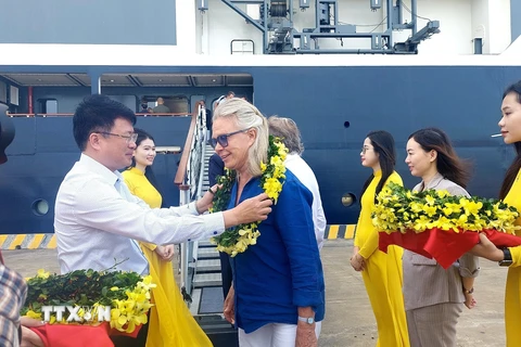 Lãnh đạo Sở Du lịch Quảng Ninh và thành phố Hạ Long tặng hoa chào đón các du khách cập Cảng tàu khách Quốc tế Hạ Long. (Ảnh: TTXVN phát)