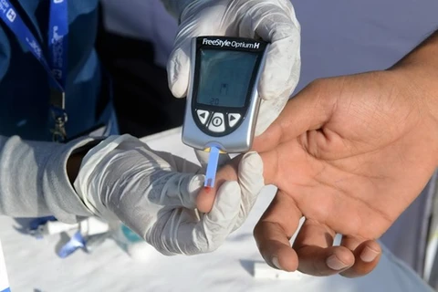 Nhân viên y tế lấy mẫu máu để thử đường huyết cho một bệnh nhân tại một trung tâm y tế ở Hyderabad. (Nguồn: AFP/TTXVN)