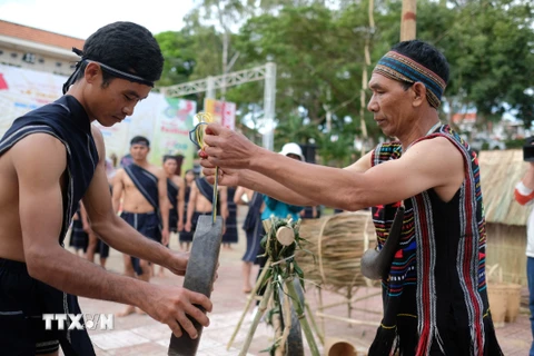 Sau khi xin phép Yàng, các già làng sẽ trao chiêng cho những chàng trai trong buôn làng để diễn tấu bài chiêng truyền thống Mừng lúa mới của người K’Ho. (Ảnh: Nguyễn Dũng/TTXVN) 