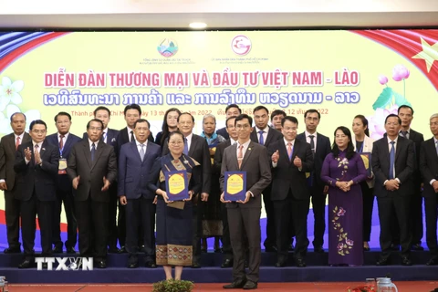 Nghi thức trao biên bản ghi nhớ hợp tác và hợp đồng kinh tế giữa các doanh nghiệp Việt Nam-Lào tại diễn đàn. (Ảnh: Xuân Anh/TTXVN)