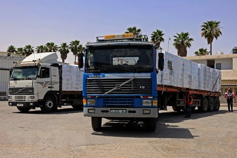 Xe chở hàng cứu trợ qua cửa khẩu Rafah vào Dải Gaza. (Ảnh: AFP/TTXVN)