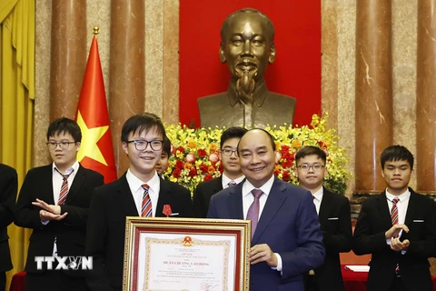 Chủ tịch nước Nguyễn Xuân Phúc trao tặng Huân chương Lao động hạng Nhì và hạng Ba cho các học sinh đoạt giải các cuộc thi Olympic và Khoa học kỹ thuật quốc tế năm 2022. (Ảnh: Thống Nhất/TTXVN) 