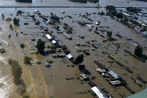 Những ngôi nhà ở thành phố Đồng Giang (Trung Quốc) chìm trong nước lũ do mực nước sông Hắc Long Giang dâng cao. (Ảnh: AFP/TTXVN) 