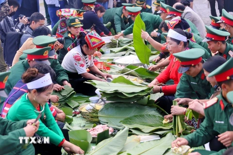 Chiến sỹ và đồng bào tham gia gói Bánh chưng xanh tại Làng Văn hóa-Du lịch các dân tộc Việt Nam. (Ảnh: Tuấn Đức/TTXVN) 