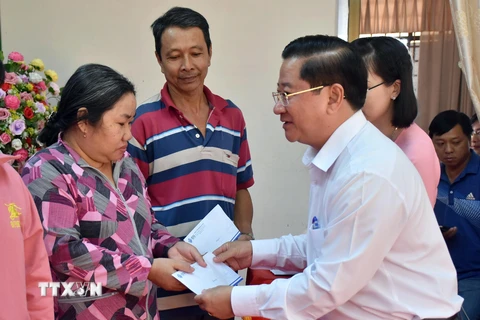 Chủ tịch Ủy ban Nhân dân thành phố Cần Thơ Trần Việt Trường (bên phải) trao tặng quà Tết hỗ trợ cho người dân khó khăn. (Ảnh: Trung Kiên/TTXVN) 