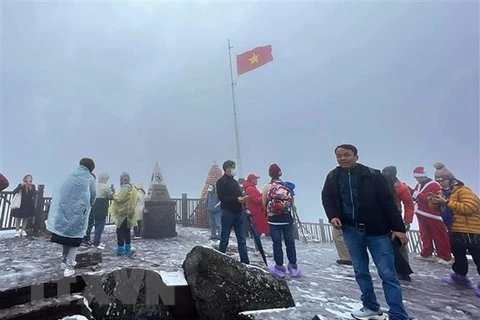 Khách du lịch chụp ảnh lưu niệm trên đỉnh Fansipan. (Ảnh: Quốc Khánh/TTXVN) 