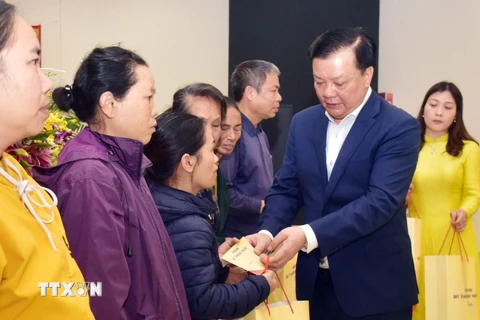 Bí thư Thành ủy Hà Nội Đinh Tiến Dũng tặng quà Tết cho các hộ gia đình có hoàn cảnh khó khăn trên địa bàn huyện Gia Lâm. (Ảnh: Văn Điệp/TTXVN)