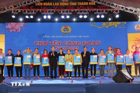 Ông Võ Mạnh Sơn (thứ 7, trái sang), Chủ tịch Liên đoàn Lao động tỉnh Thanh Hóa trao quà cho công nhân có hoàn cảnh khó khăn tại chương trình. (Ảnh: Khiếu Tư/TTXVN)