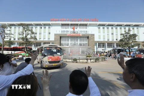 Hình ảnh tập thể lãnh đạo, nhân viên y tế Bệnh viện K tiễn đoàn xe đưa bệnh nhân và người nhà về quê đón tết. (Ảnh: Minh Quyết/TTXVN) 