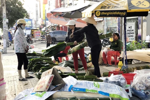 Người dân mua lá dong về gói bánh chưng tại chợ phiên trên tuyến đường Cách Mạng Tháng Tám, quận Tân Bình, Thành phố Hồ Chí Minh. (Ảnh: Mỹ Phương/TTXVN)