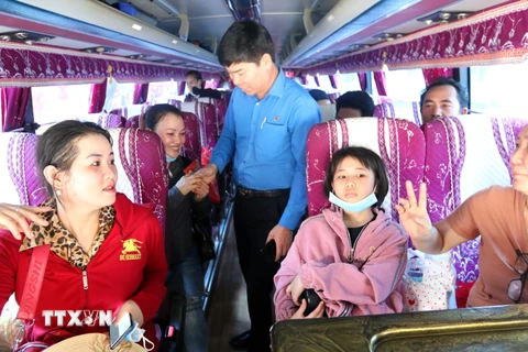 Ông Phạm Chí Tâm, Phó Chủ tịch Liên đoàn Lao động Thành phố Hồ Chí Minh lên tận ôtô tiễn công nhân về quê đón Tết. (Ảnh: Thanh Vũ/TTXVN)