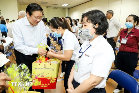 Trưởng Ban Nội chính Trung ương Phan Đình Trạc thăm hỏi, chúc Tết, tặng quà cho công nhân tại Bình Dương. (Ảnh: TTXVN phát)