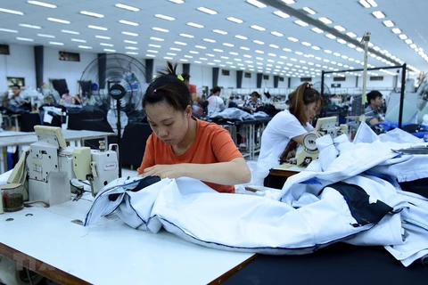 Công nhân sản xuất hàng may mặc tại Công ty trách nhiệm hữu hạn Kydo Việt Nam. (Ảnh: Phạm Kiên/TTXVN) 