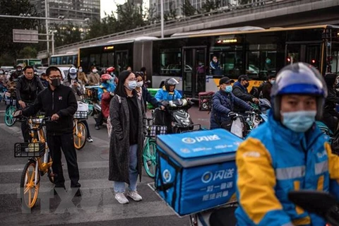 Người dân trên đường phố tại thủ đô Bắc Kinh, Trung Quốc. (Ảnh: AFP/ TTXVN) 