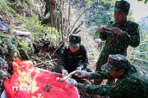 Cẩn thận quy tập những mảnh hài cốt còn sót lại của các liệt sĩ đã nằm lại trên chiến trường Vị Xuyên, sớm đưa các đồng đội trở về. (Ảnh: Hoàng Hiếu/TTXVN) 