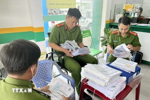 Lực lượng công an kiểm tra tại trụ sở chính của Công ty F88 ở địa chỉ 414, Quốc lộ 91, thị trấn Cái Dầu, huyện Châu Phú, tỉnh An Giang. (Ảnh: Công Mạo/TTXVN)