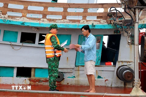 Cán bộ biên phòng Đồn Biên phòng Sông Đốc (Bộ đội Biên phòng tỉnh Cà Mau) kiểm tra tàu cá, phòng chống khai thác IUU. (Ảnh: Hồng Đạt/TTXVN) 