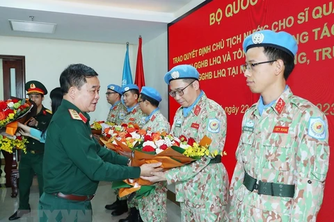Thượng tướng Hoàng Xuân Chiến, Thứ trưởng Bộ Quốc phòng tặng hoa chúc mừng các sỹ quan vừa hoàn thành nhiệm vụ trở về. (Ảnh: Trọng Đức/TTXVN)
