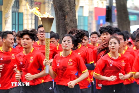 Vận động viên điền kinh Nguyễn Thị Huyền cùng các vận động viên tiêu biểu tham gia rước đuốc. (Ảnh: Tuấn Đức/TTXVN) 