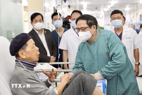 Thủ tướng Phạm Minh Chính thăm bệnh nhân đang chữa bệnh tại bệnh viện Bạch Mai. (Ảnh: Dương Giang/TTXVN) 