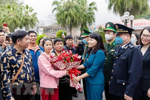 Lãnh đạo thành phố Móng Cái tặng hoa chúc mừng các đoàn khách quốc tế đầu tiên qua cửa khẩu quốc tế Móng Cái. (Ảnh: TTXVN phát)