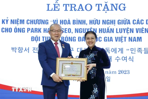 Chủ tịch Liên hiệp các tổ chức hữu nghị Việt Nam Nguyễn Phương Nga trao Kỷ niệm chương cho ông Park Hang Seo. (Ảnh: An Đăng/TTXVN)