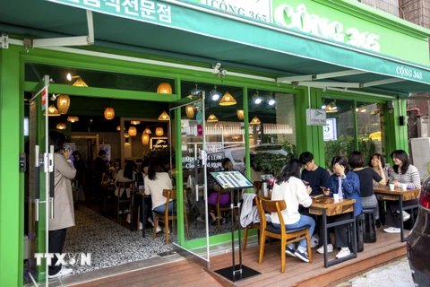 Mặc dù thời tiết bắt đầu nắng nóng song thực khách Hàn Quốc vẫn chấp nhận ngồi bên ngoài để thưởng thức món ăn truyền thống Việt Nam tại nhà hàng Cộng 365. (Ảnh: Anh Nguyên/TTXVN) 