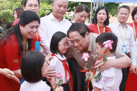 Thủ tướng Phạm Minh Chính thăm học sinh có hoàn cảnh đặc biệt khó khăn của Trường Phổ thông dân lập Herman Gmeiner. (Ảnh: Dương Giang/TTXVN) 