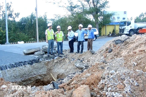 Cán bộ, kỹ sư của Khu Quản lý đường bộ 3 (Cục đường bộ Việt Nam) kiểm tra vị trí hố sâu để đưa ra giải pháp khắc phục. (Ảnh: Xuân Triệu/TTXVN