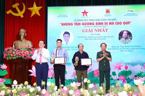 Trưởng Ban Tuyên giáo Trung ương Nguyễn Trọng Nghĩa và Trung tướng Trịnh Văn Quyết, Phó Chủ nhiệm Tổng cục Chính trị Quân đội Nhân dân Việt Nam trao giải Nhất cho các tác giả. (Ảnh: Văn Điệp/TTXVN)