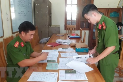 Cán bộ công an tỉnh Thái Bình thu thập hồ sơ, tài liệu trong một vụ án lừa đảo đi làm việc nước ngoài. (Ảnh: TTXVN phát)
