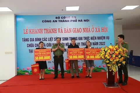 Trung tướng Nguyễn Hải Trung, Bí thư Đảng ủy, Giám đốc Công an thành phố Hà Nội tặng quà cho nhân thân các liệt sỹ phòng cháy chữa cháy quận Cầu Giấy. (Nguồn: Bộ Công an) 