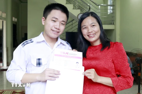 Nguyễn Mạnh Thắng chia sẻ niềm vui với cô giáo chủ nhiệm Nguyễn Thị Hường. (Ảnh: Đồng Thúy/TTXVN)