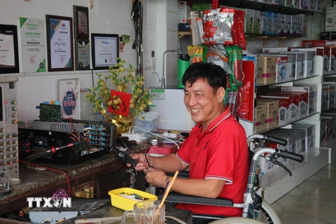 Ông Nguyễn Văn Quởn làm việc tại cửa hàng của mình. (Ảnh: Minh Trí/TTXVN)