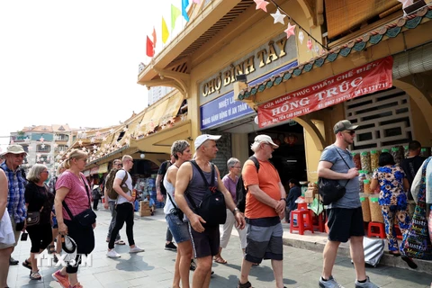 Đoàn khách quốc tế tham quan Chợ Bình Tây, ngôi chợ có kiến trúc đẹp bậc nhất Thành phố Hồ Chí Minh. (Ảnh: Hồng Đạt/TTXVN)