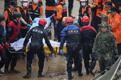 Lực lượng cứu hộ di chuyển nạn nhân vụ ngập lụt. (Nguồn: Reuters) 