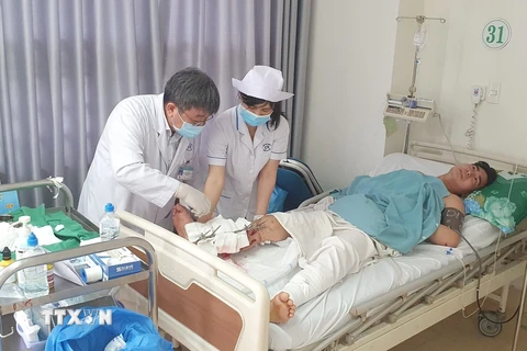 Các bác sỹ Bệnh viện Bà Rịa thăm khám vết mổ cho anh N.V.H (27 tuổi) sau khi anh được nối thành công cẳng chân bị đứt gần lìa do tai nạn giao thông. (Ảnh: TTXVN phát)